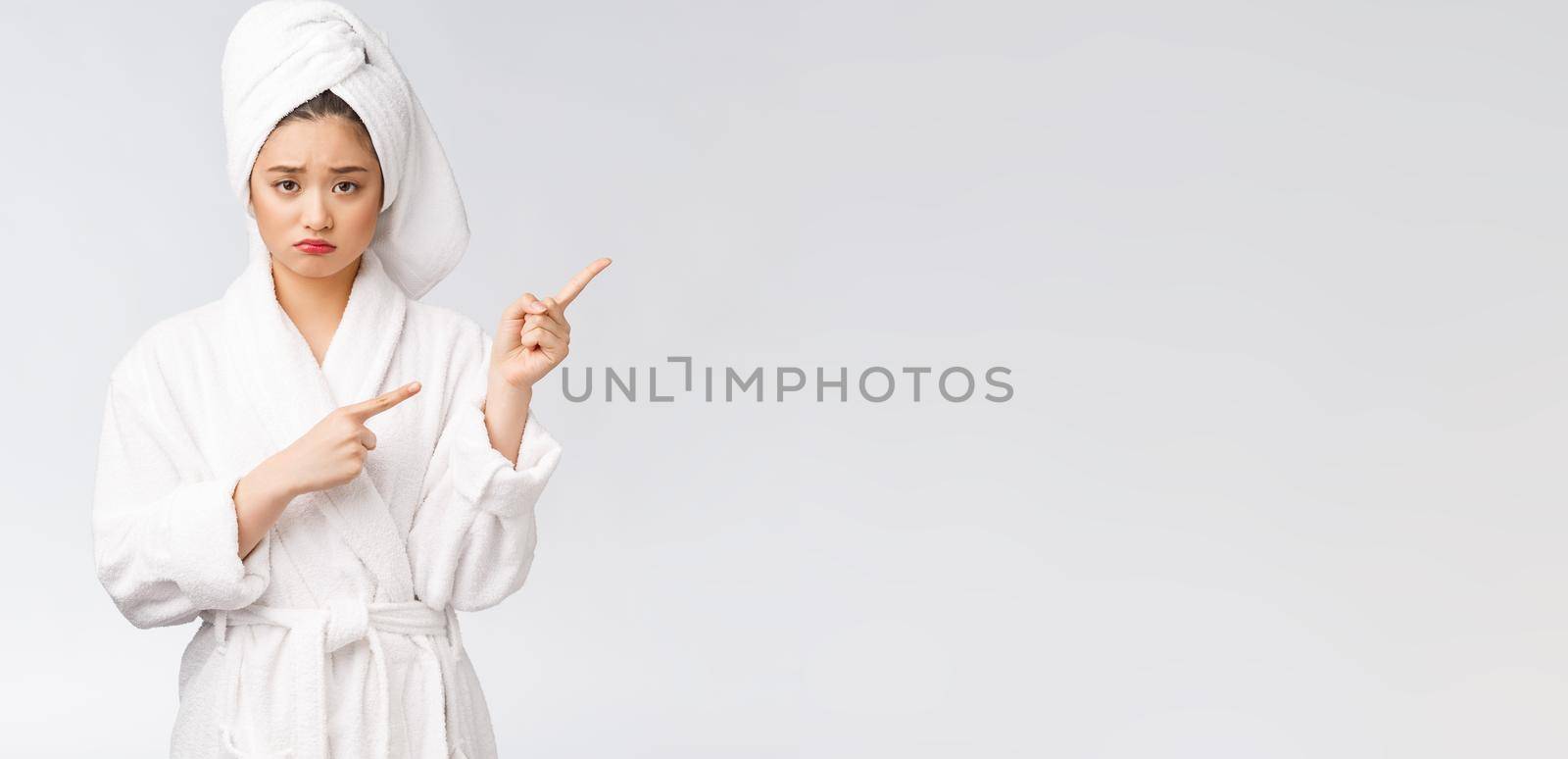 Young beautiful woman wearing shower towel after bath over isolated white background pointing with finger