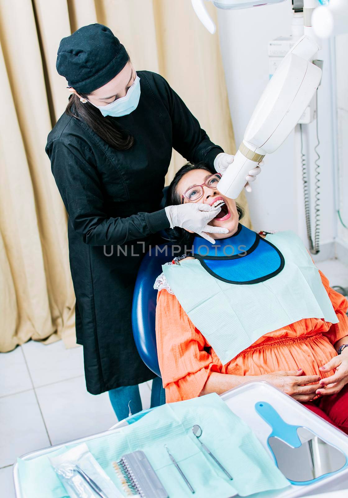 Female dentist doing dental x-ray, Female dentist doing x-ray to patient, female dentist doing dental x-ray, dental x-ray concept by isaiphoto