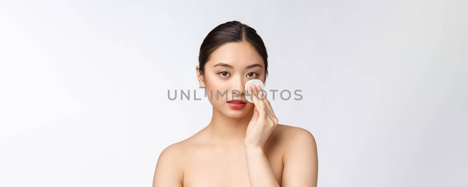 skin care woman removing face makeup with cotton swab pad - skin care concept. Facial closeup of beautiful mixed race model with perfect skin. by Benzoix