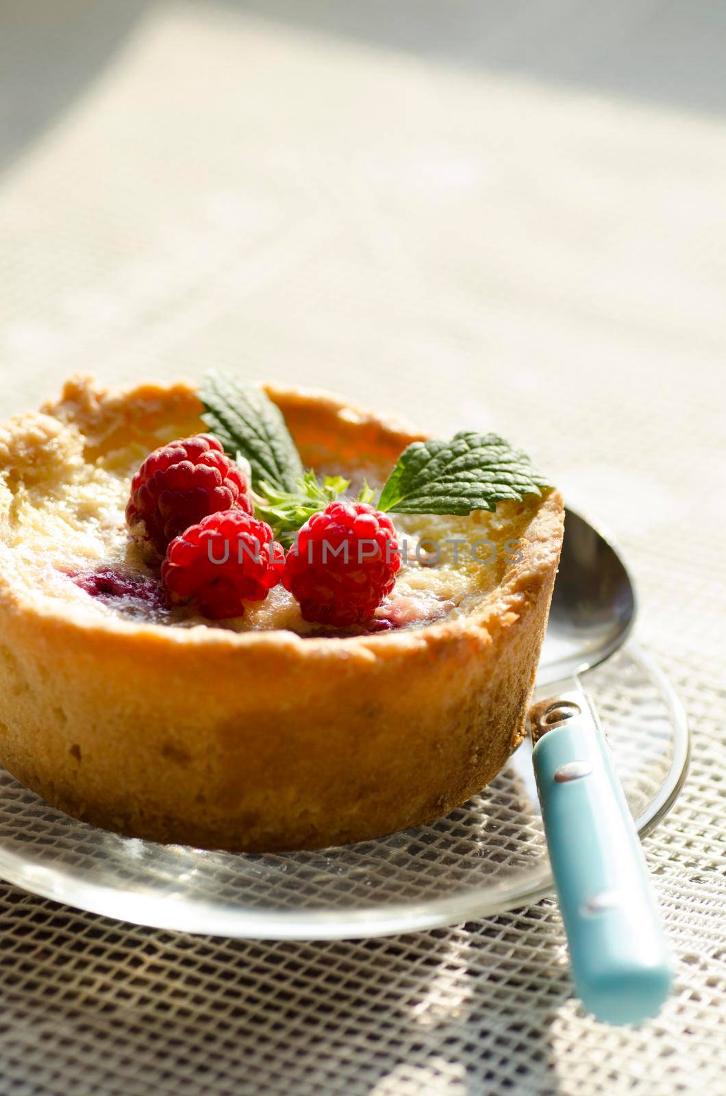 Mini berry tarts decorated with raspberries