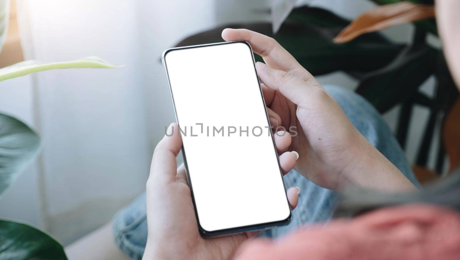 Top view Woman sitting and holding blank screen mock up mobile phone.