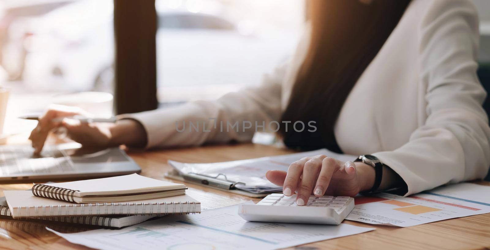 Close up Businessman using calculator and laptop for calaulating finance, tax, accounting, statistics and analytic research concept.