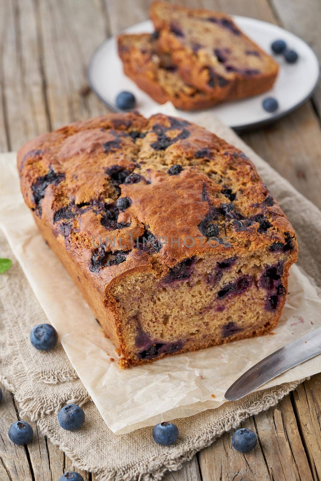 Banana bread on old wooden rustic table, slice of a cake with banana, vertical