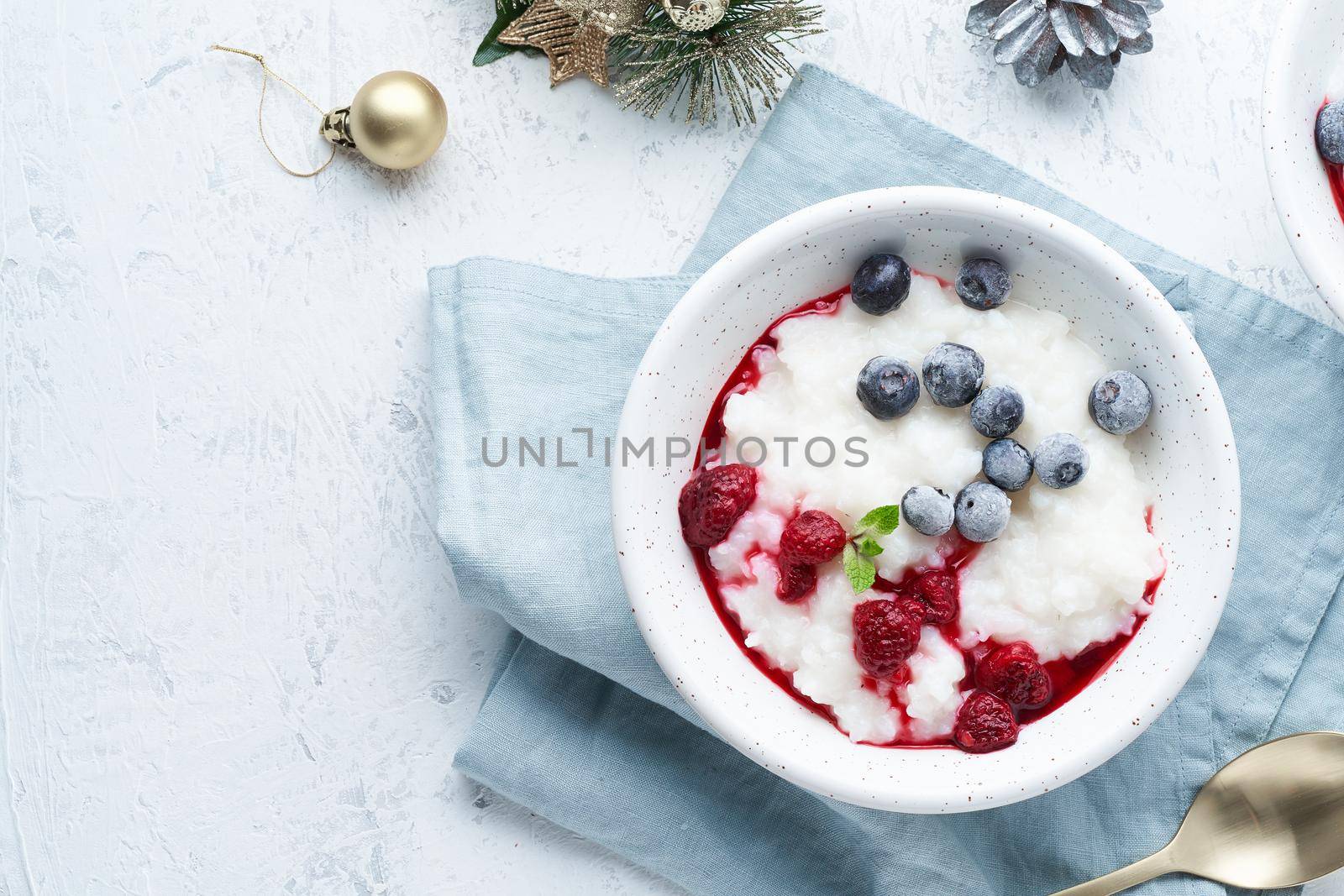 Christmas food, Vegan Coconut Rice Pudding, top view, copy space. Healthy diet breakfast with a berries, scandinavian minimalism