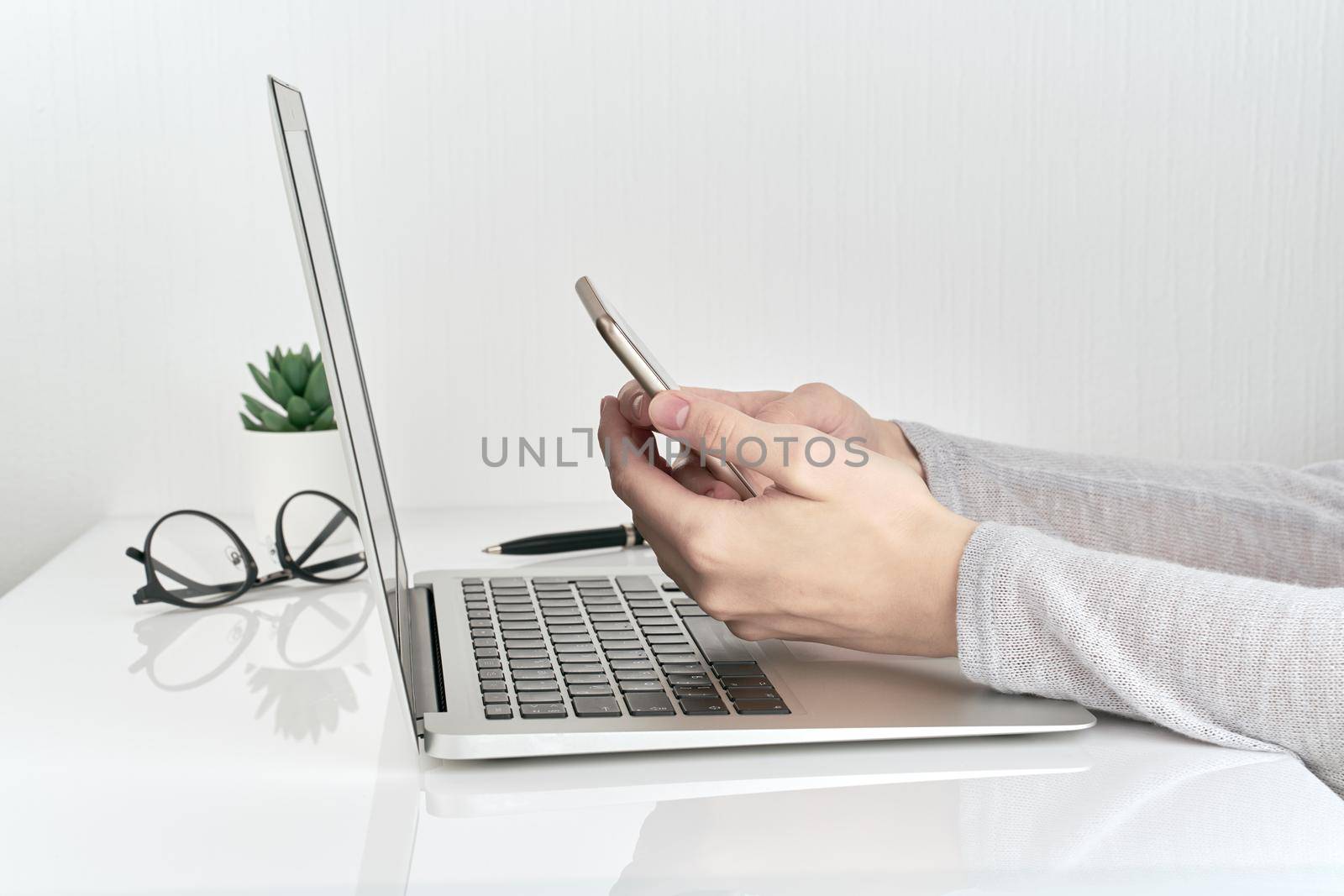 female person working on computer and phone, bussineswoman typing and using devices