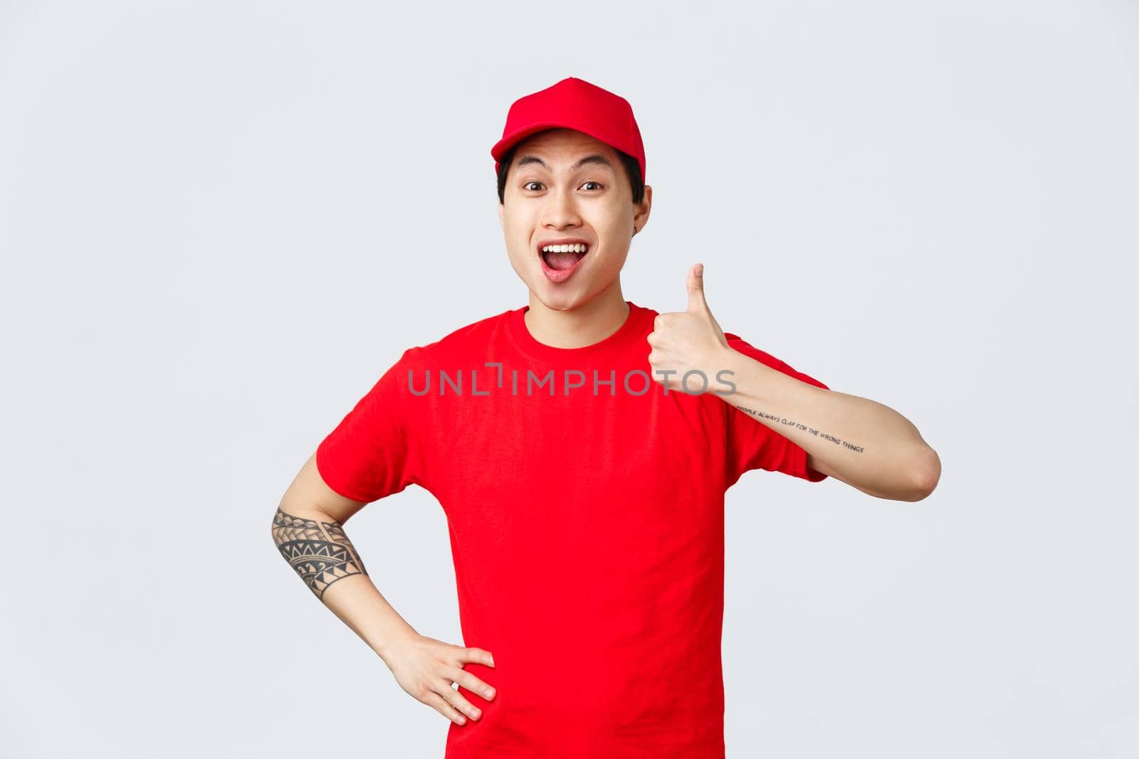Very good delivery company. Cheerful asian courier in uniform, red cap and t-shirt, encourage shop safely and use company service for ordering and receiving parcels, thumb-up in approval.