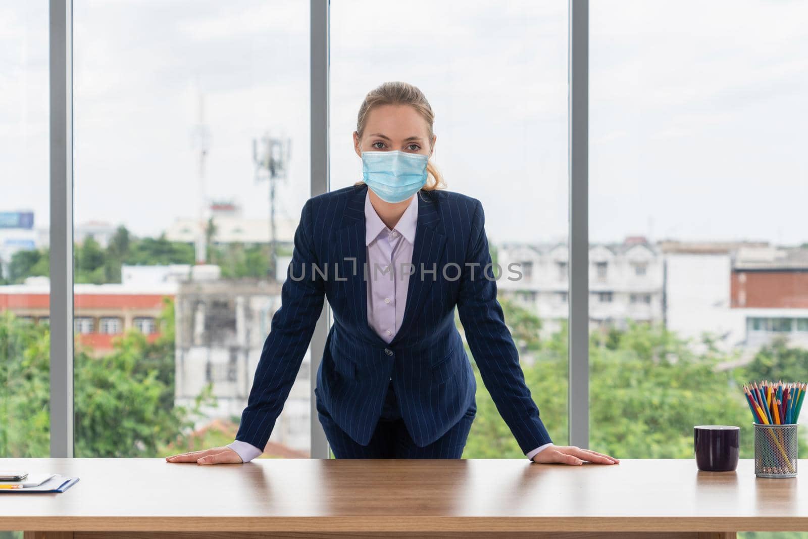 Office worker with face mask quarantine from coronavirus or COVID-19. Concept of protective working environment to reopen business and stop spreading of coronavirus or COVID-19.
