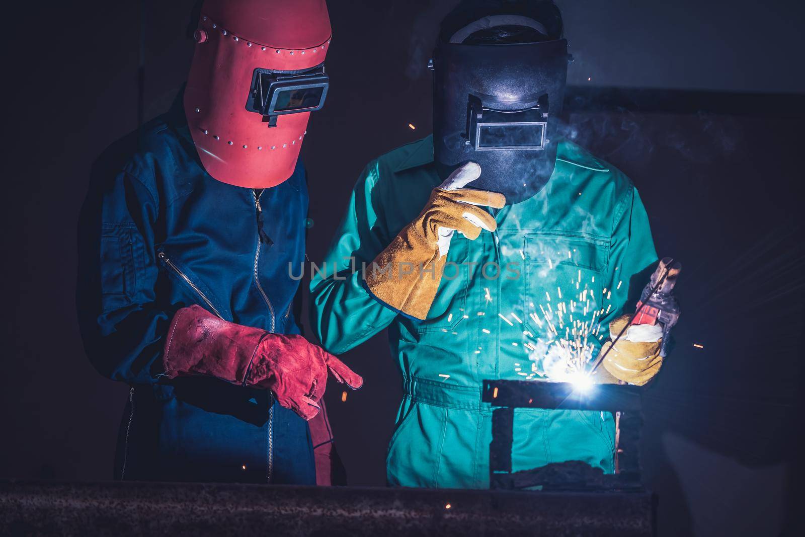 Metal welding steel works using electric arc welding machine to weld steel at factory. Metalwork manufacturing and construction maintenance service by manual skill labor concept.
