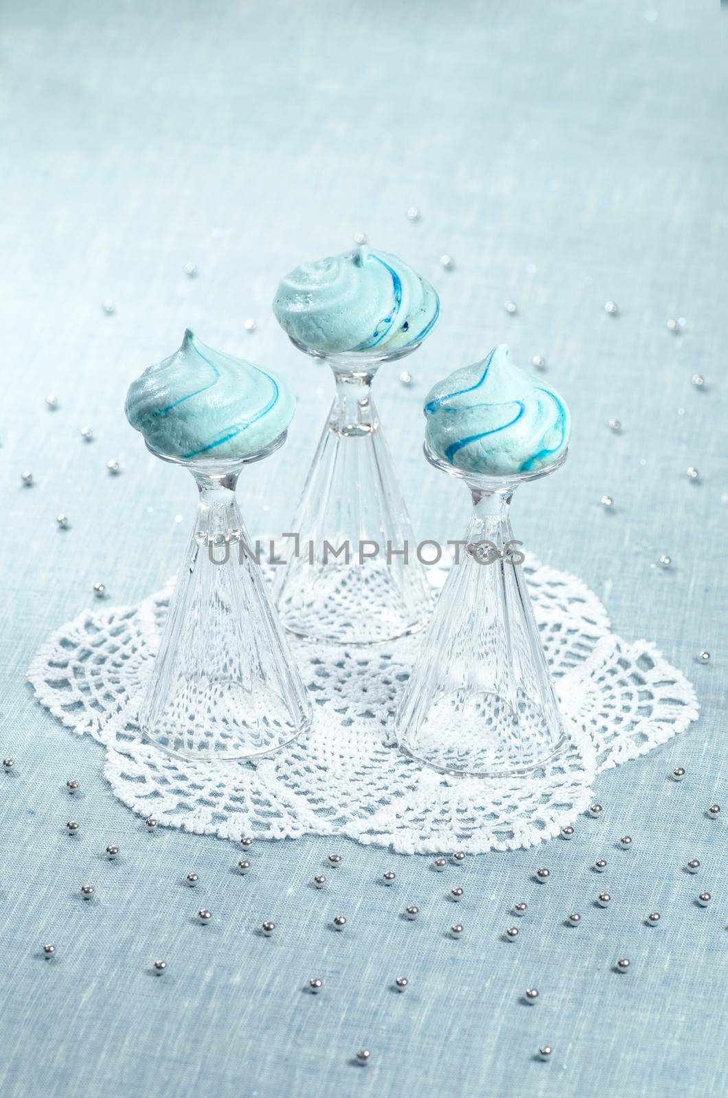 Three homemade meringue shaped domes on crystal wine-glasses, blurred background From series Christmas and New Year