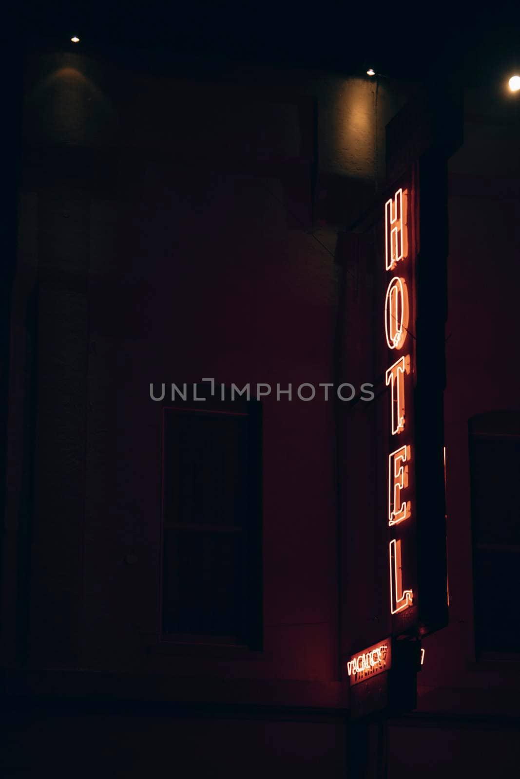 Facade of a Hotel with a window and a neon light sign