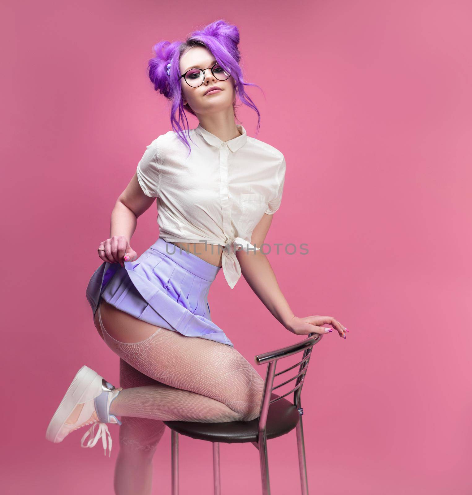 the sexy schoolgirl girl with purple hair in summer short clothes and beautiful underwear on a pink background