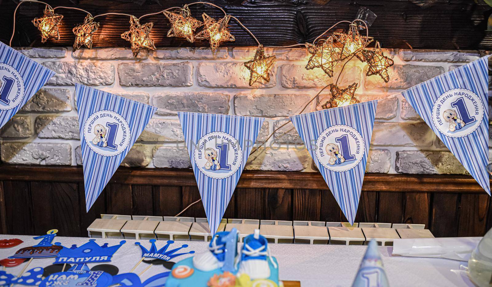 White-blue decoration in honor of the child birthday. a children's party for a boy. Inscriptions: First birthday. Daddy. Mommy.