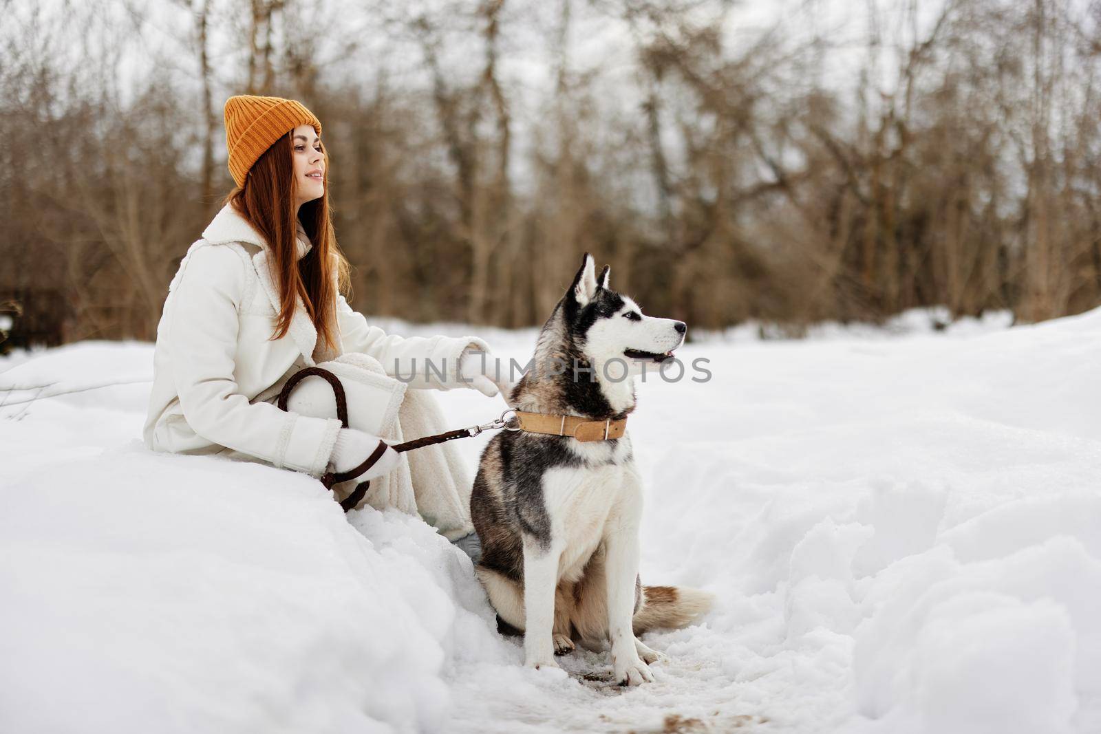 woman in the snow playing with a dog fun friendship winter holidays. High quality photo