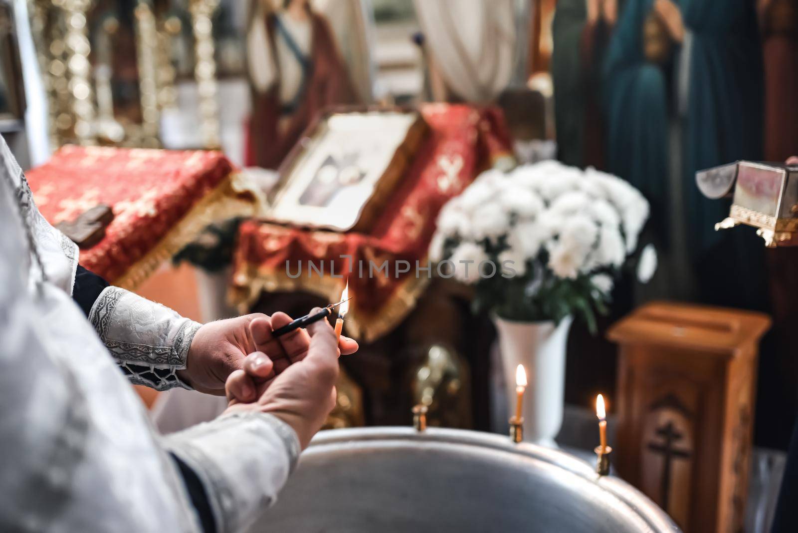 The priest blesses the child with water. The sacrament of the baptism of a small European child in the church.