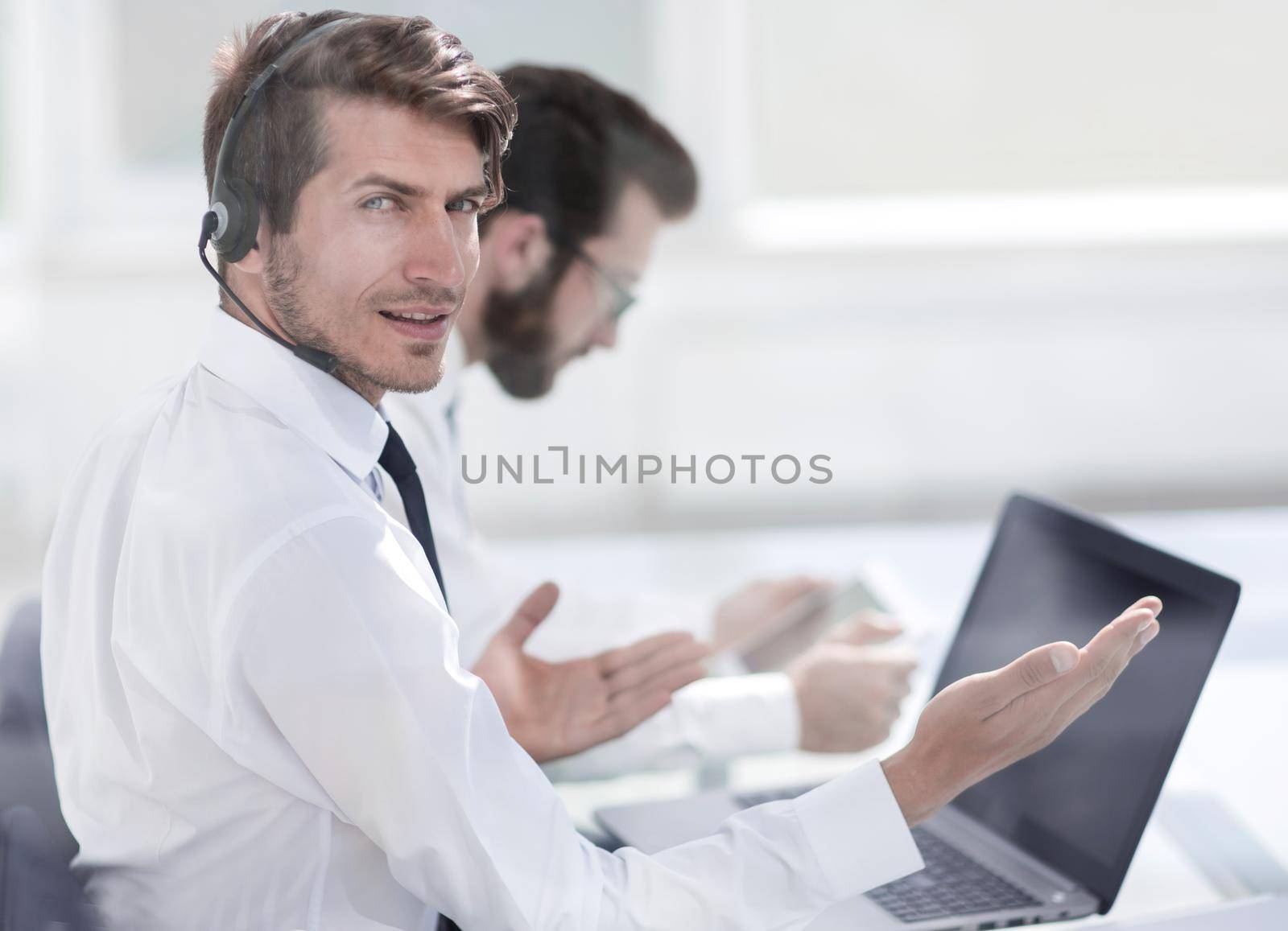 consultant in headphones sitting at his Desk.business concept