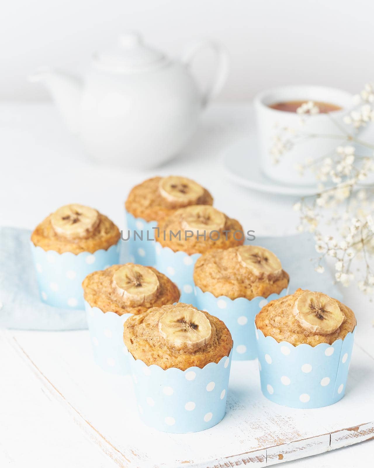 Banana muffin, cupcakes in blue cake cases paper, white concrete table by NataBene