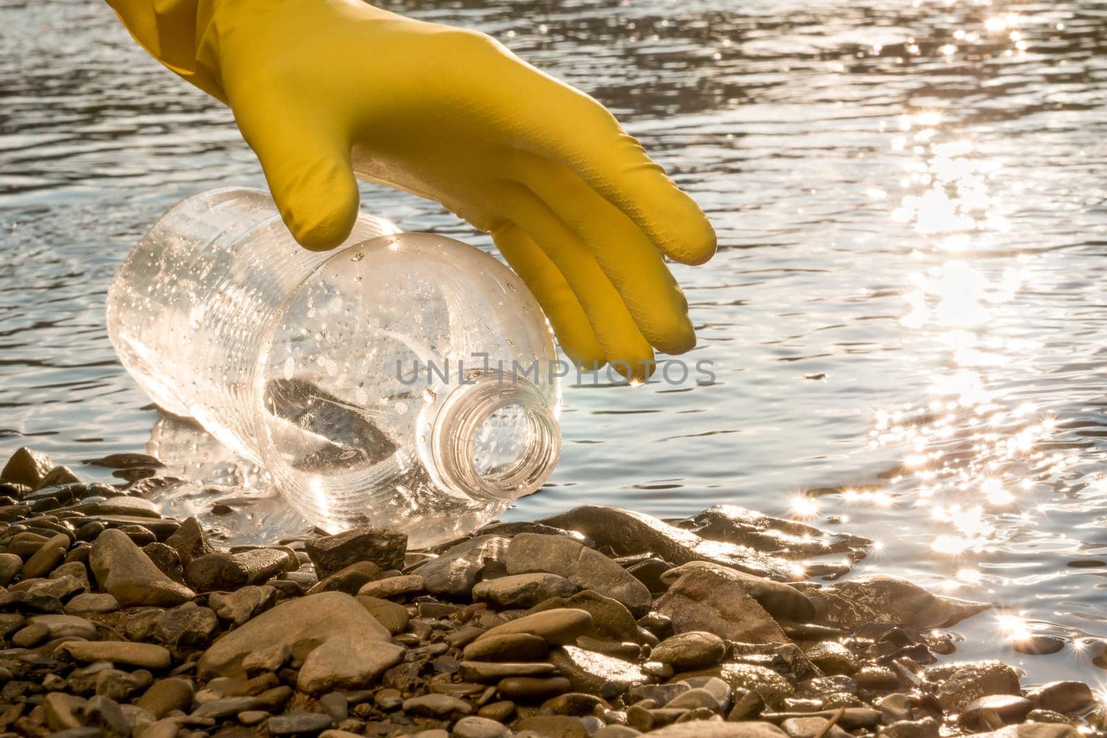 Volunteer cleaning river trash pick up litter picking shore. Collect garbage river. Picking up garbage water plastic nature. Cleaning beach waste plastic bottle PET. Cleaning trash beach garbage shore