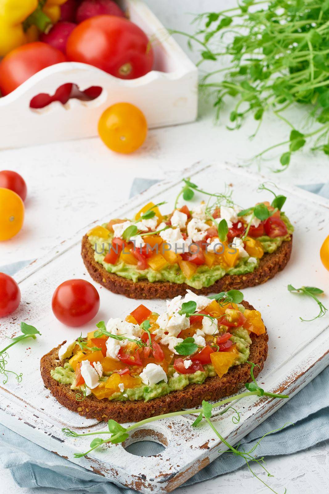 avocado toast with feta and tomatoes, smorrebrod with ricotta, closeup and vertical by NataBene