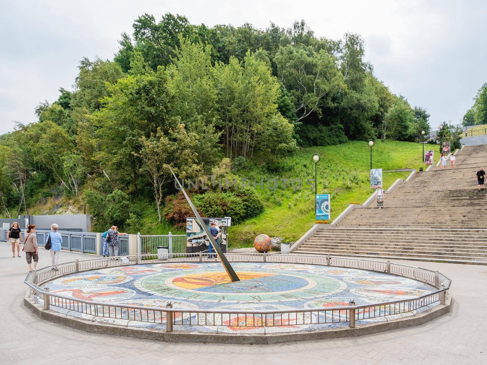 SVETLOGORSK, RUSSIA - July 21, 2019. Tourists near mosaic sun clocks Zodiak by Nikolay Frolov, art landmark of sea embankment of Svetlogorsk.