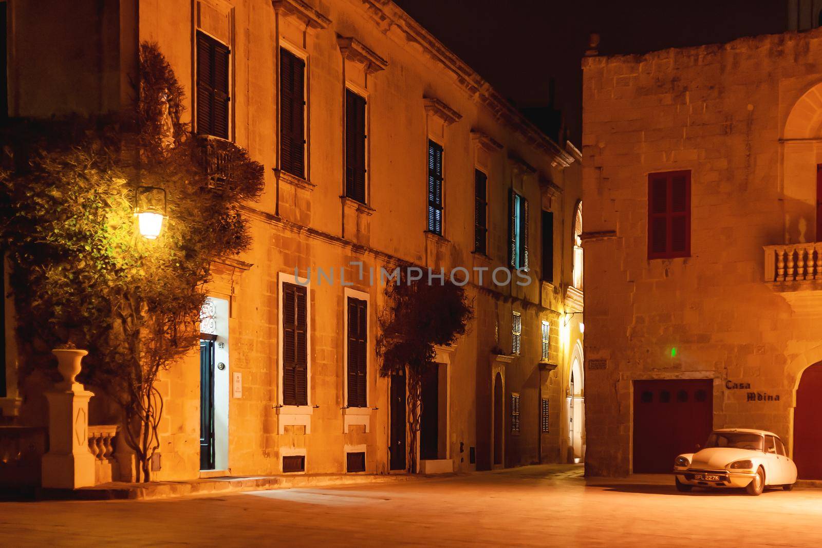 MDINA, MALTA - February 19, 2010. Illuminated streets of Mdina, ancient capital of Malta. Night view on buildings and wall decorations of ancient town. by aksenovko