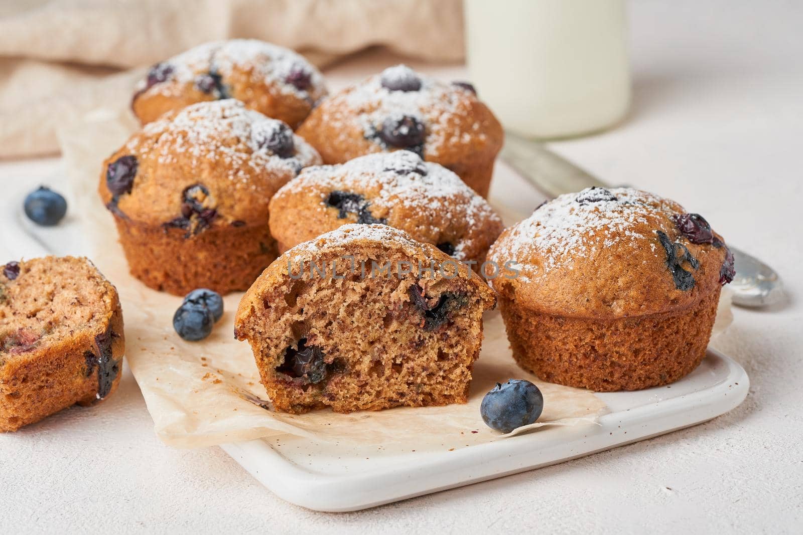 Blueberry muffin, side view, close up. Cupcakes section with berries on a white concrete table