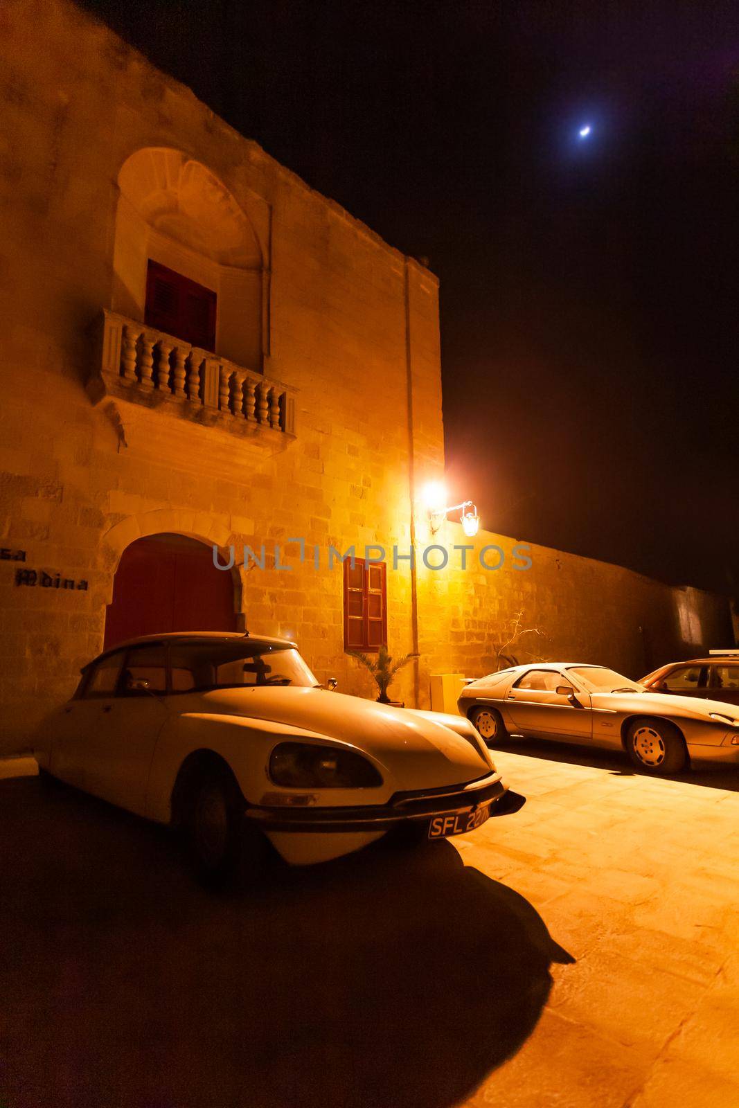 MDINA, MALTA - February 19, 2010. Old timer cars parked near stony buildings of Mdina, ancient capital of Malta. by aksenovko