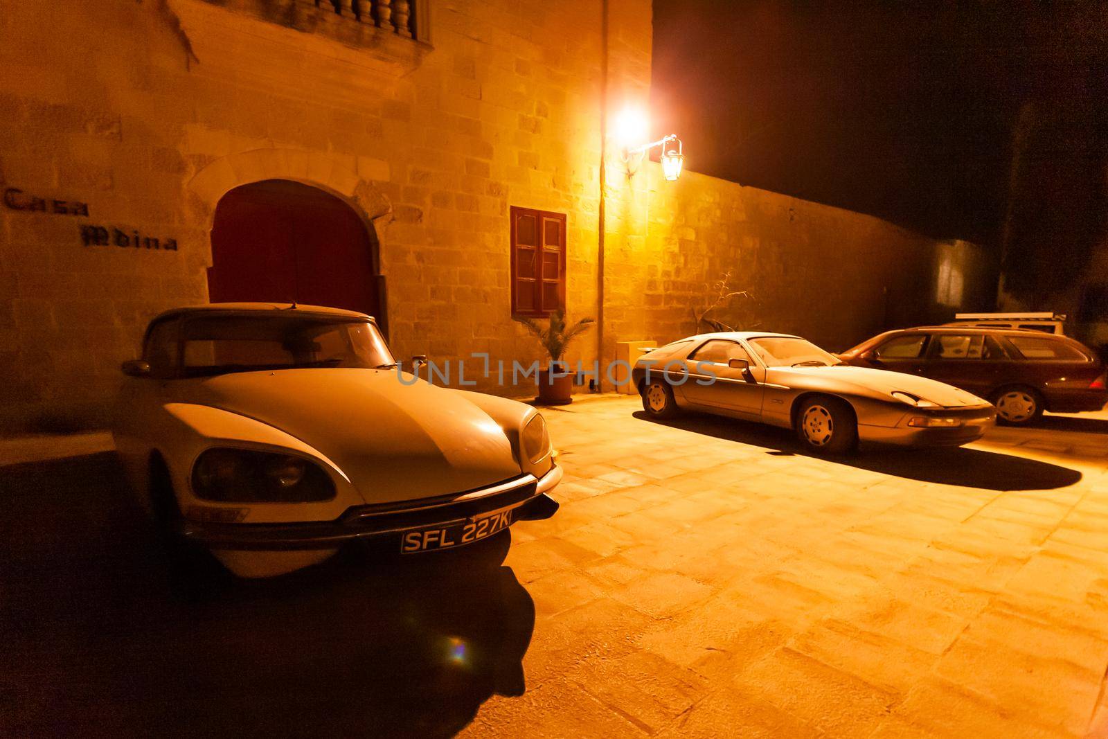 MDINA, MALTA - February 19, 2010. Old timer cars parked near stony buildings of Mdina, ancient capital of Malta. by aksenovko