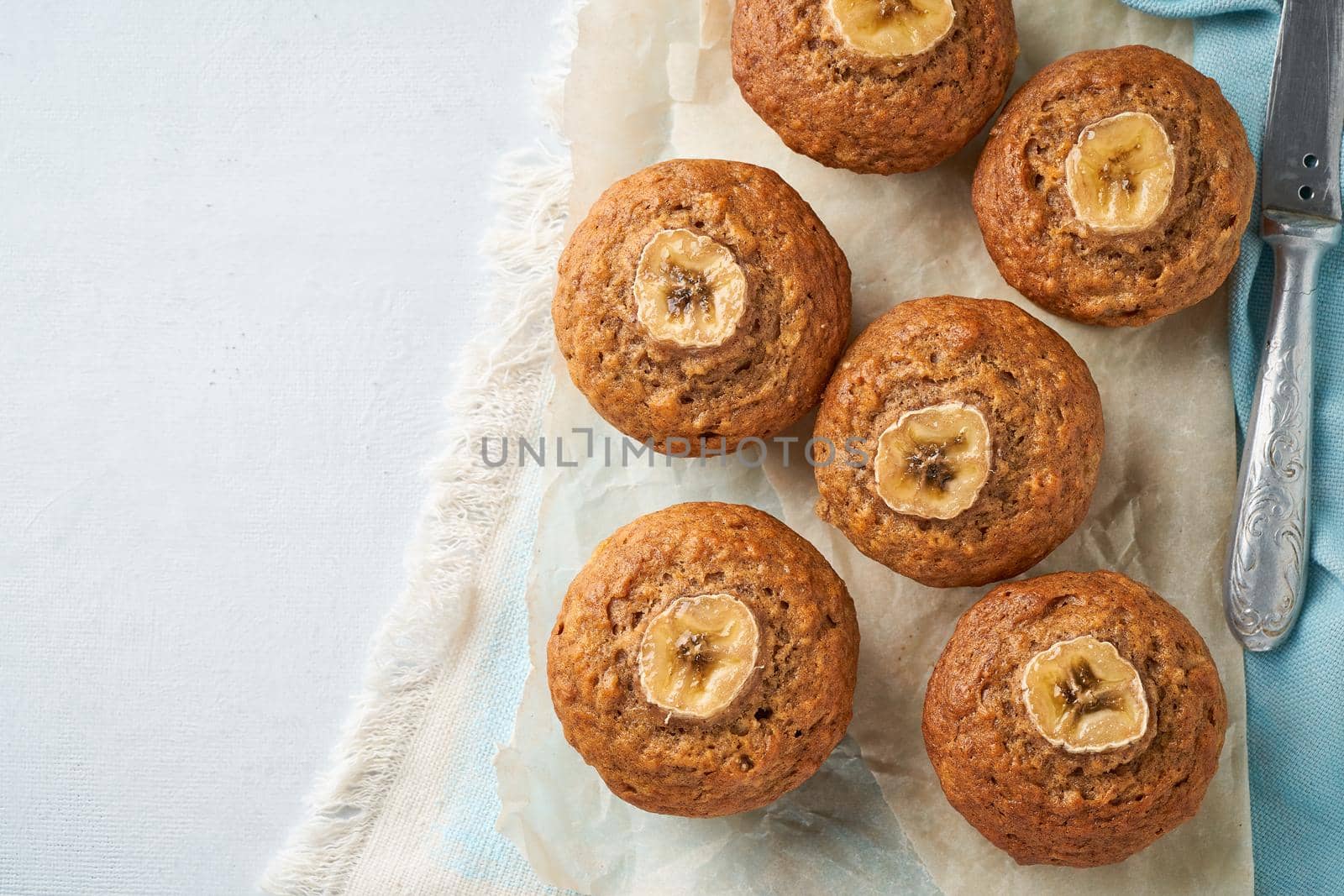 Banana muffin, top view, copy space. Cupcakes on a blue napkin, white concrete table