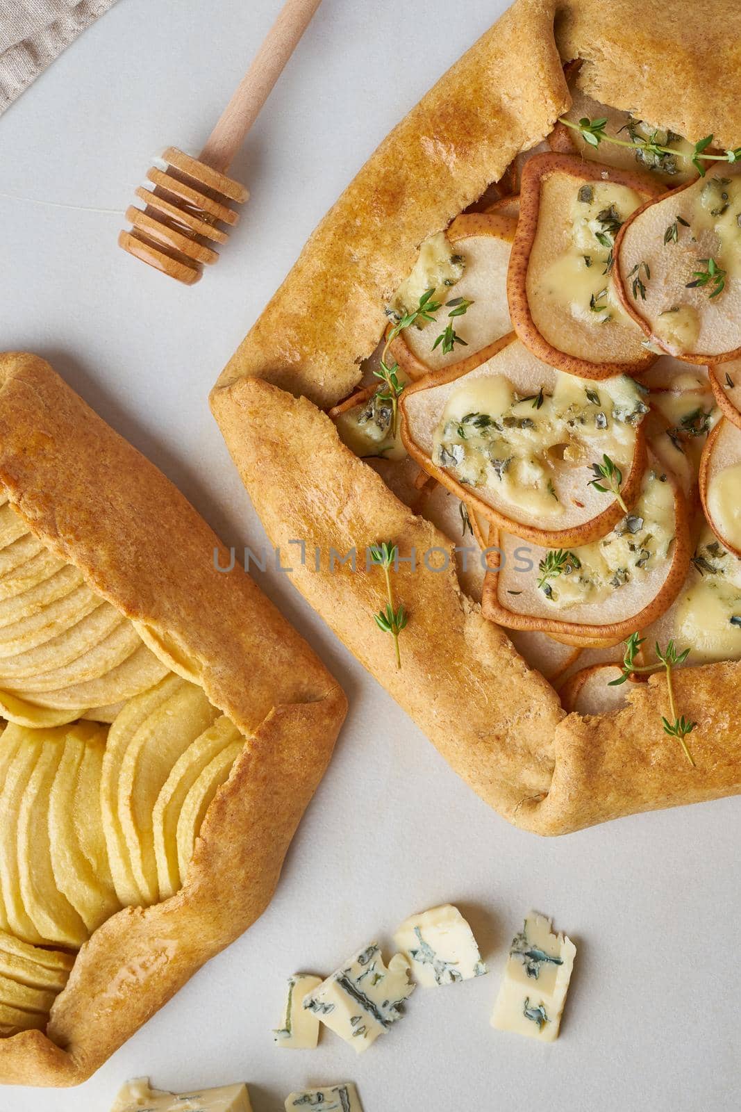 Fruit galette, apple pie with a honey, savory pear and cheese pie, marble table, vertical, top view