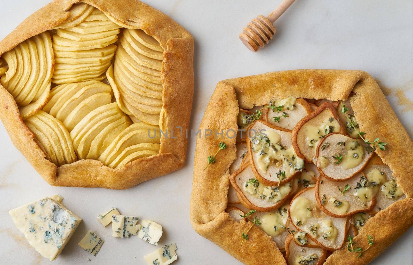Fruit galette, apple pie with a honey, savory pear and cheese pie, marble table, top view, close up