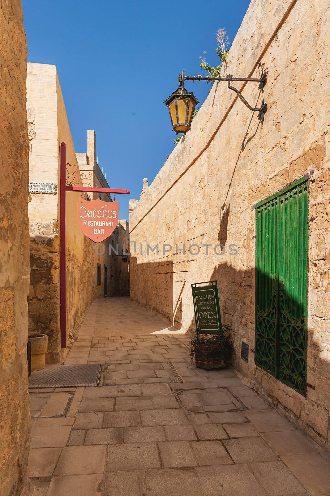 MDINA, MALTA - February 18, 2010. Nnarrow streets with cafes and restaurants. Buildings and wall decorations of ancient town.