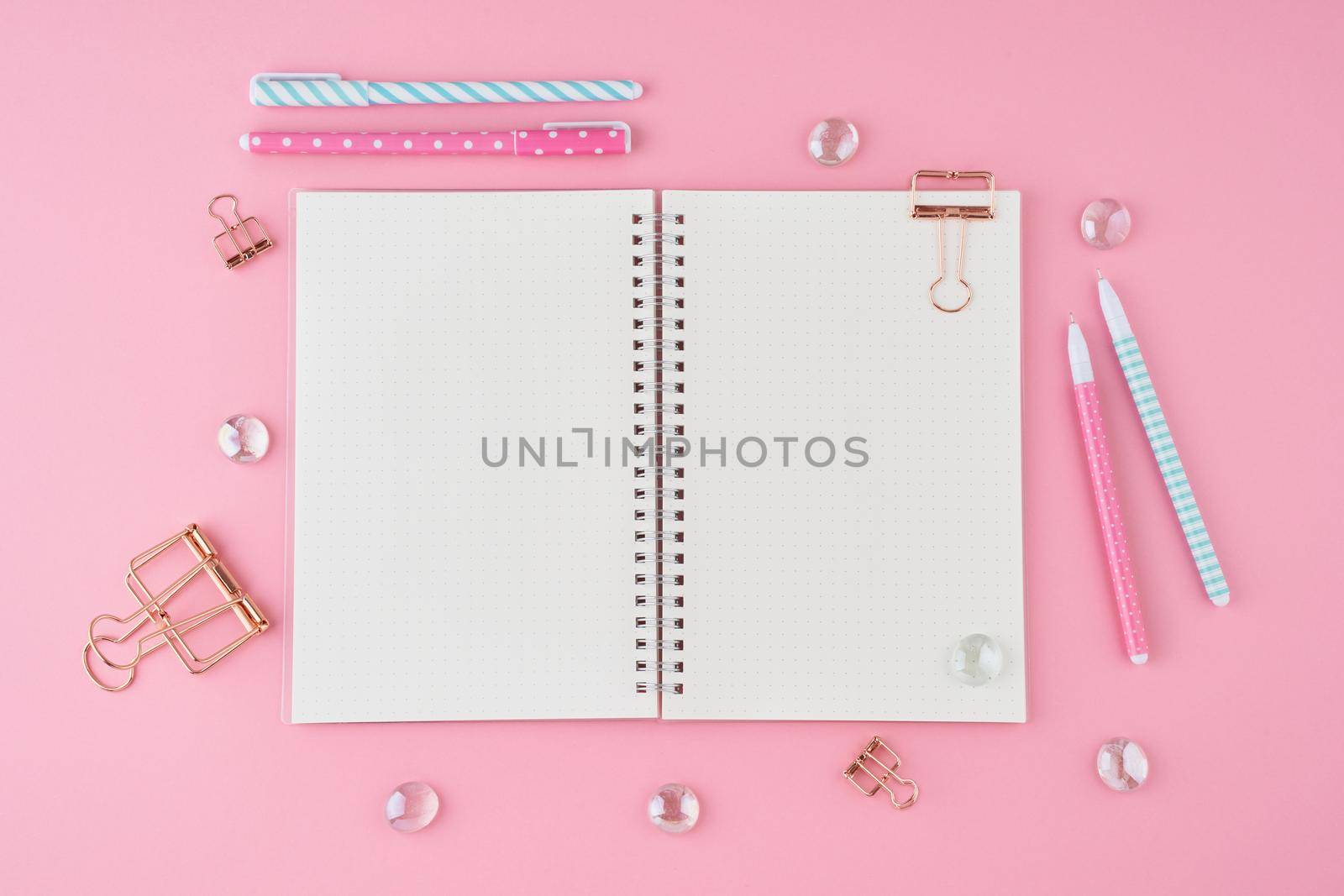 Blank notepad page in bullet journal on bright pink office desktop. Top view of modern bright table with notebook, stationery. Mock up, copy space, concept for diary by NataBene