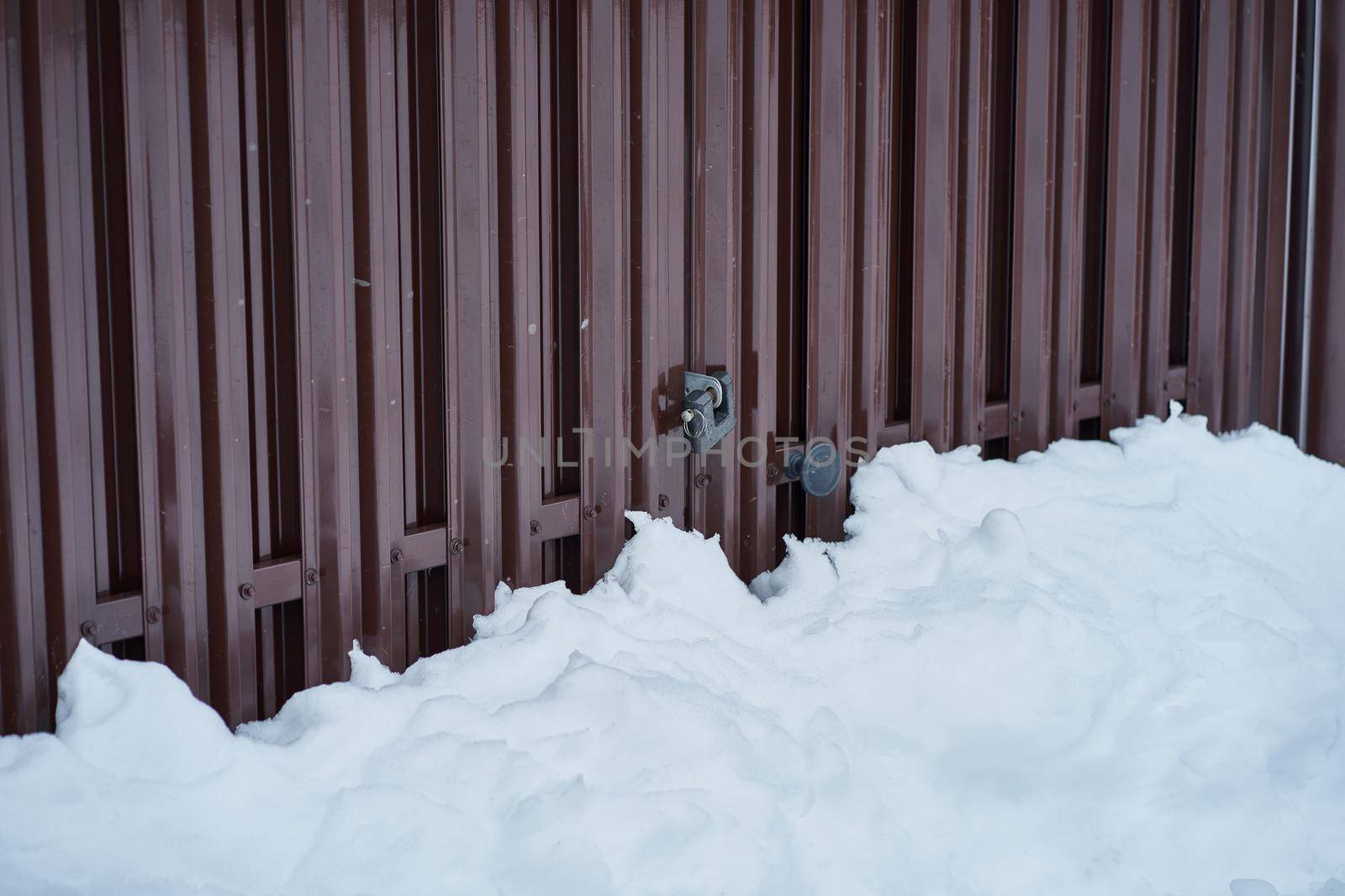 rural scene of countryside, steel fence with lock and handle, bitter cold and a lot of snow