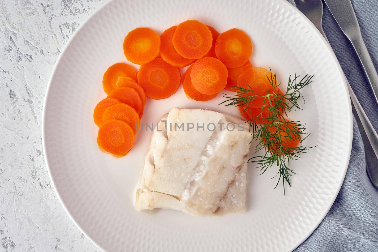 Boiled codfish with carrot and dill on white plate, fodmap dash paleo diet by NataBene