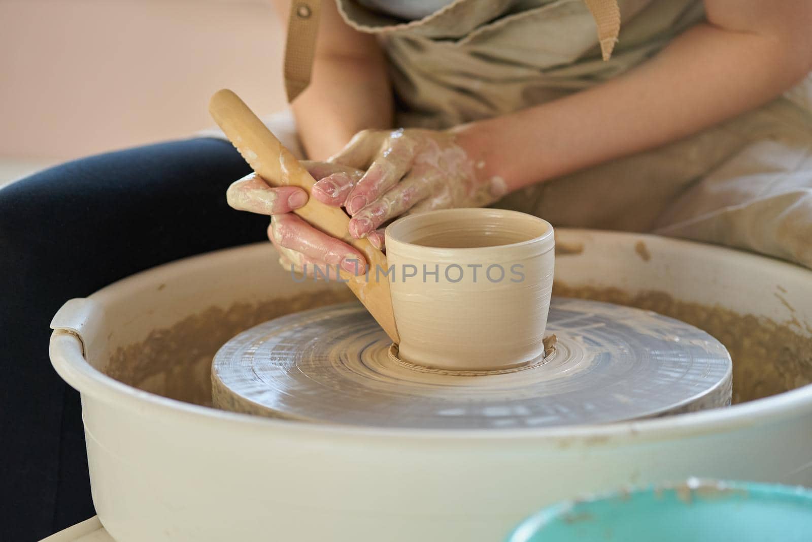 Woman making ceramic pottery on wheel, hands closeup, focus on potters, palms with pottery