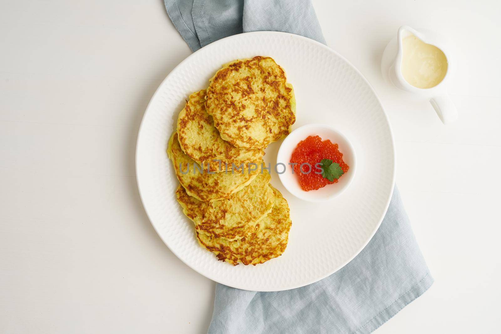 Balanced and gluten free zucchini pancakes with red caviar and sause