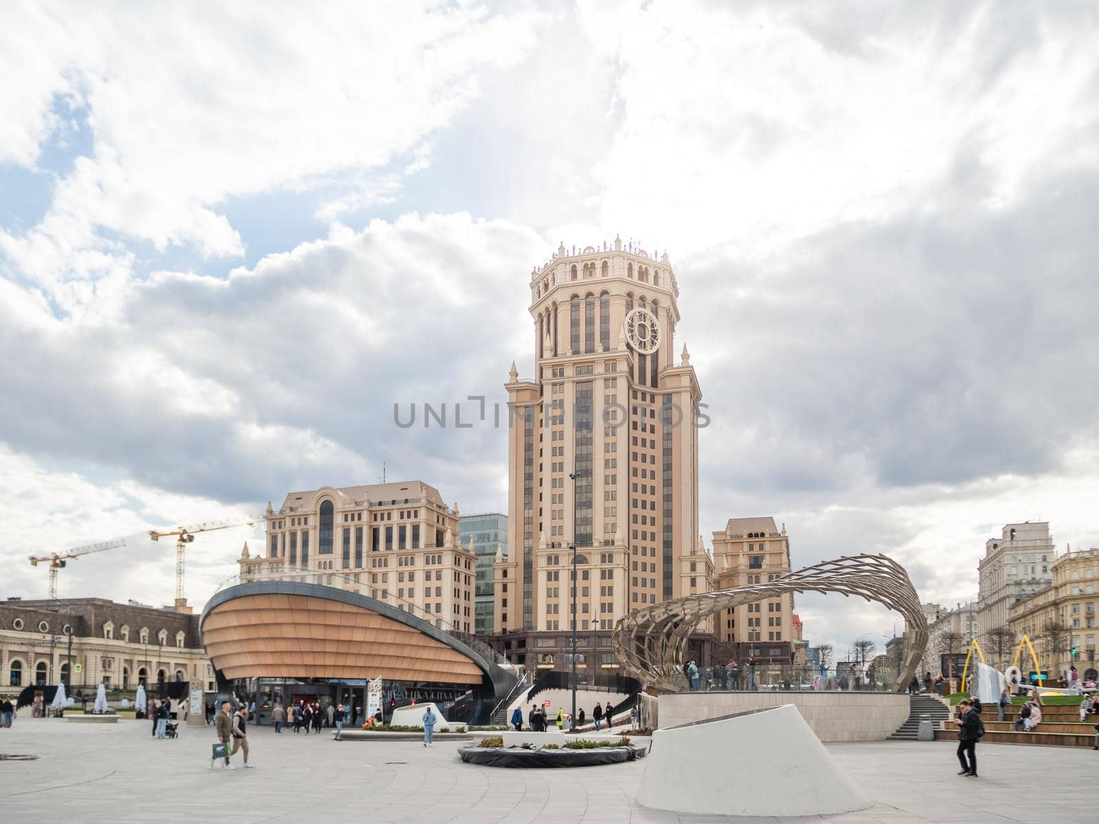 MOSCOW, RUSSIA - May 01, 2022. Local people and tourists walk on square near Paveletsky railway. Modern urban architecture. by aksenovko