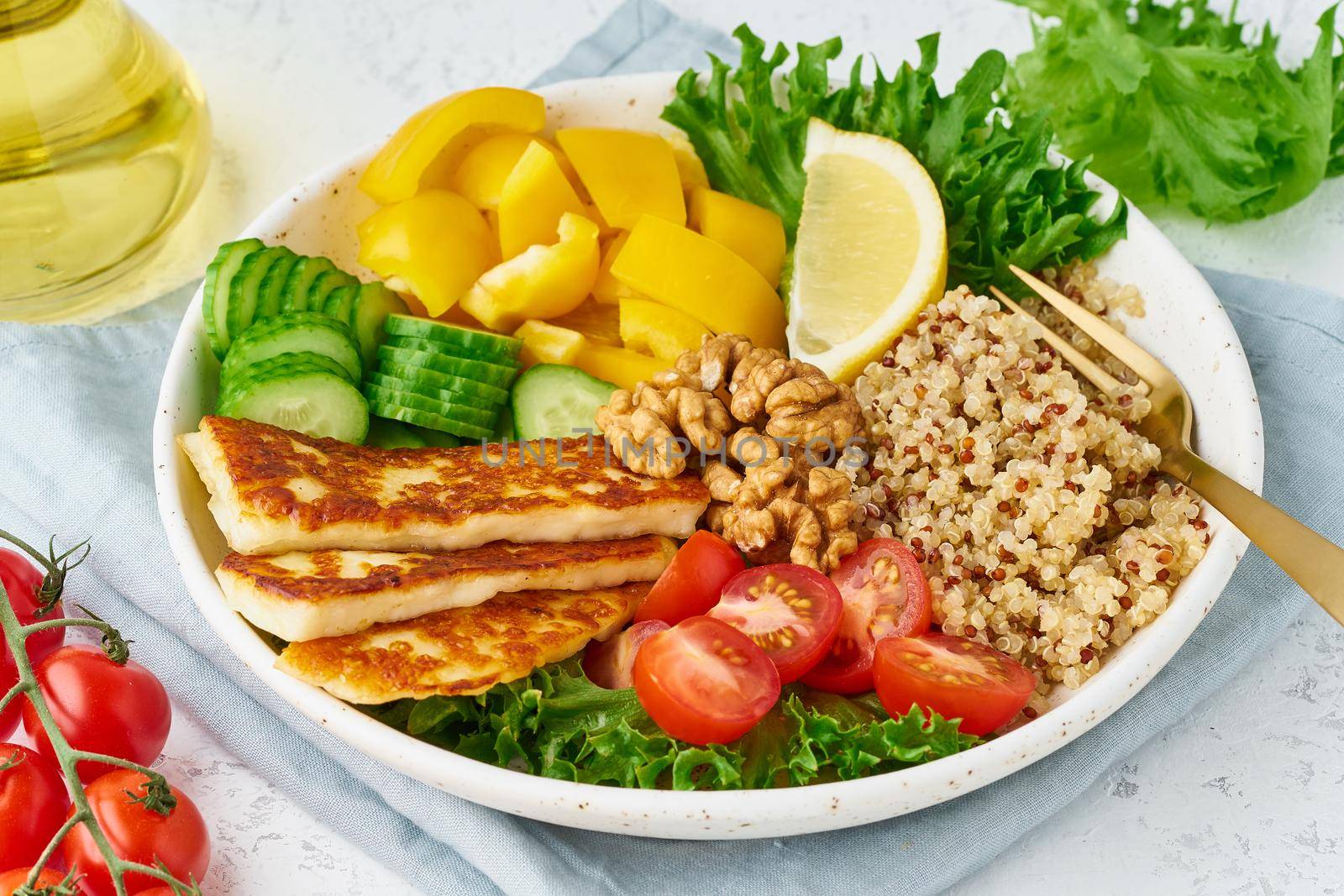 Buddha bowl with halloumi, quinoa, salad lettuce, balanced food, white background, top view