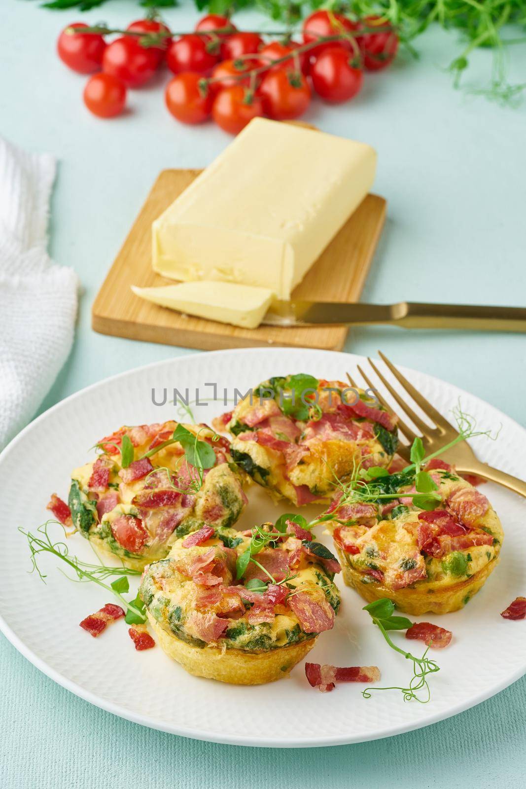 egg muffins with spinach, bacon and tomato, ketogenic keto diet low carb, pastel and modern background closeup vertical