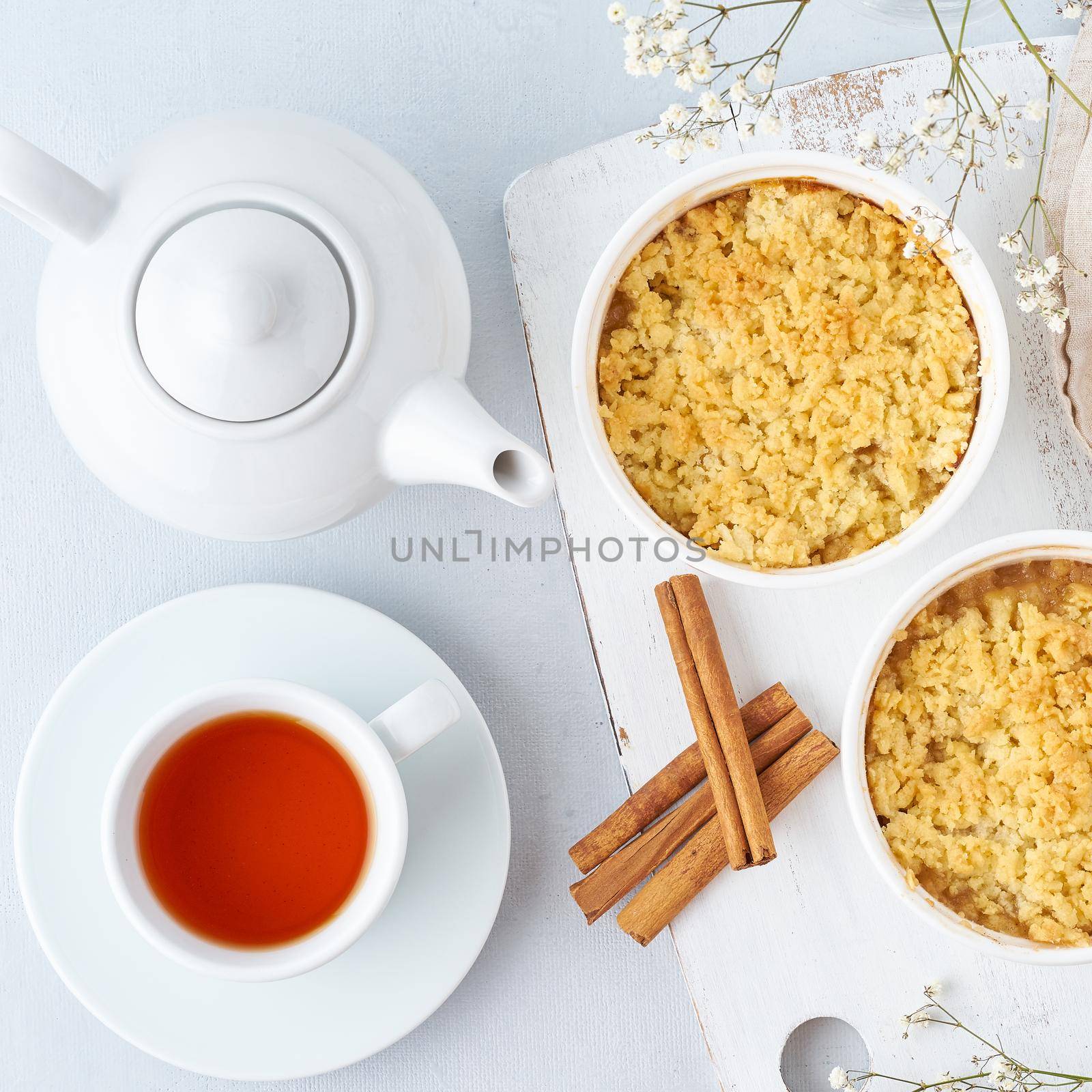 Apple crumble with streusel. Morning breakfast with tea on a light gray table. Top view, close up by NataBene