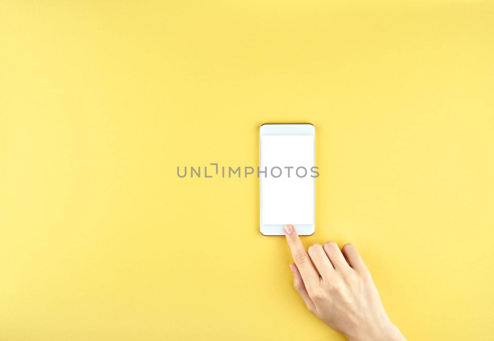 blank screen to put your own web-page or message on it, woman touching screen on mobile phone, yellow background top view copy space