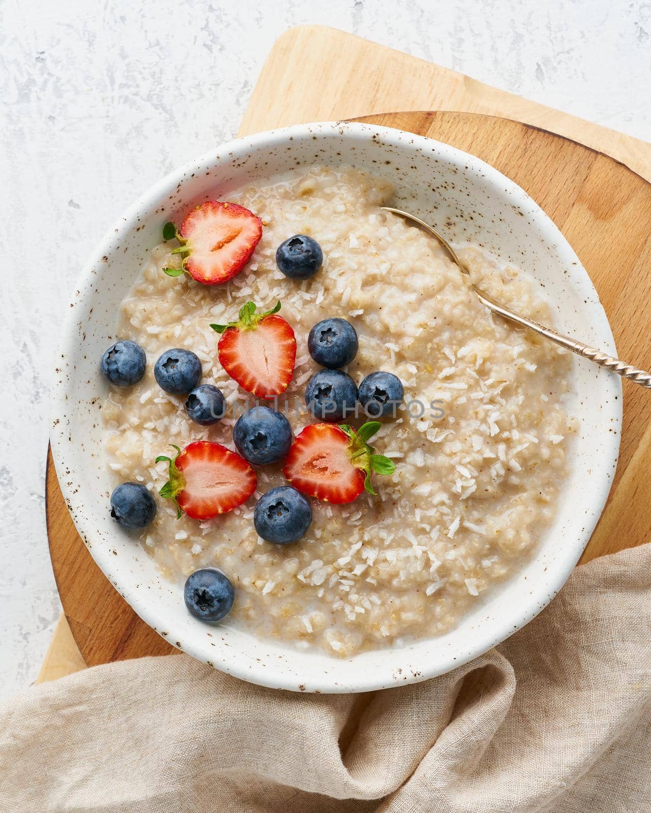 Oatmeal porridge rustic with berries, dash diet, on white wooden background top view by NataBene