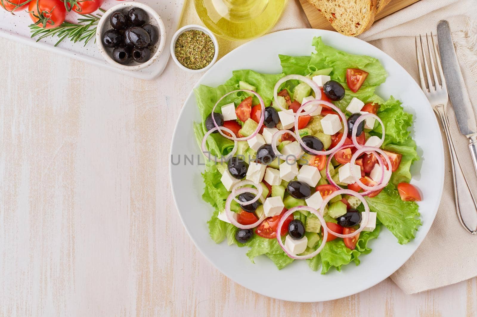 Greek salad on white plate on old rustic white wooden table, fresh salad with tomatoes, by NataBene