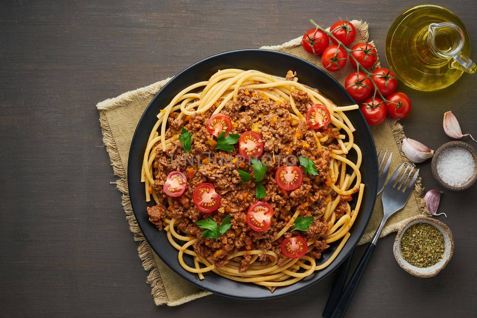 mediterranean pasta bolognese bucatini with mincemeat, tomatoes, carrot and basil leaves