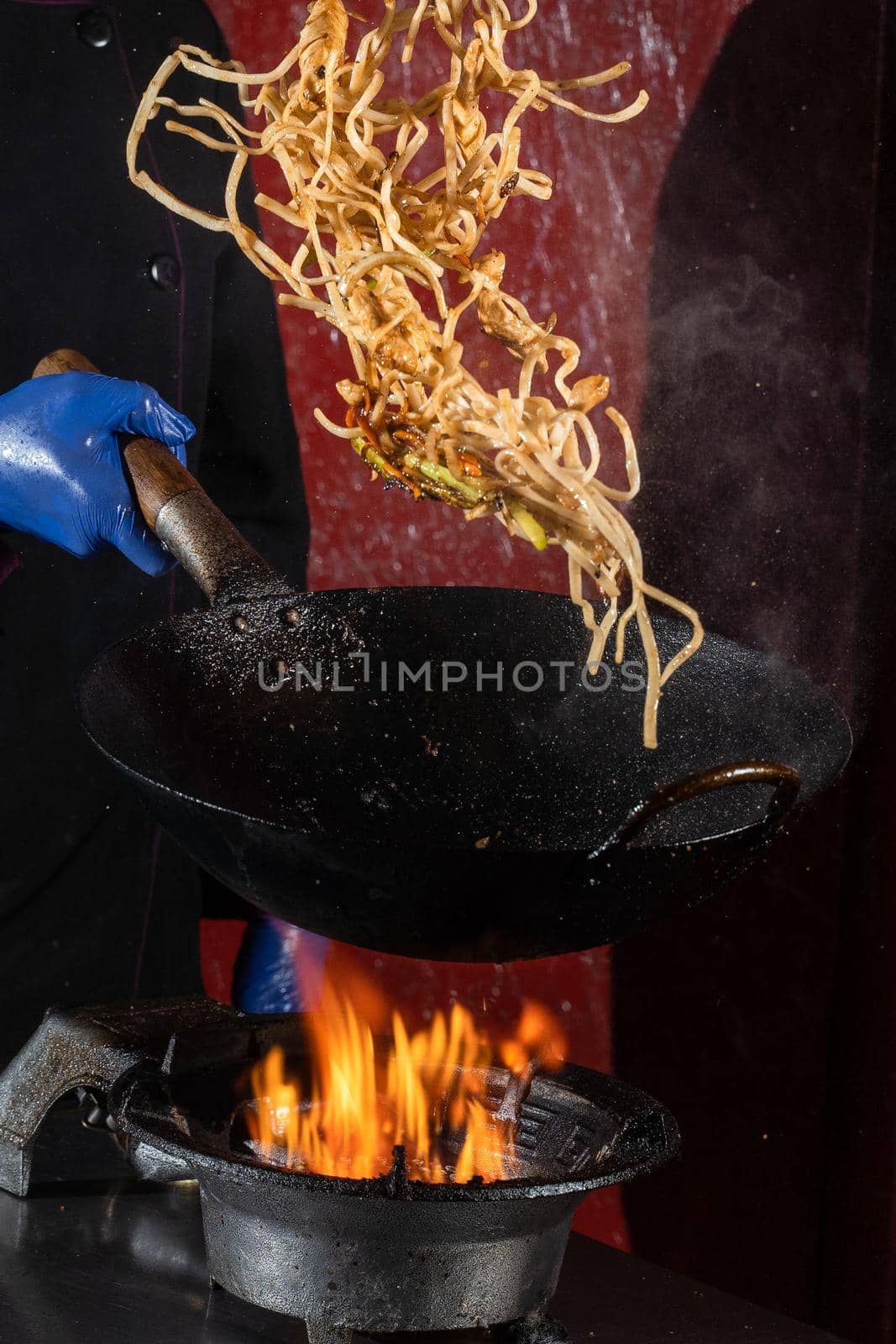 Flying noodles for wok box with meat, soy sauce fried in a wok pan, street food by Rabizo