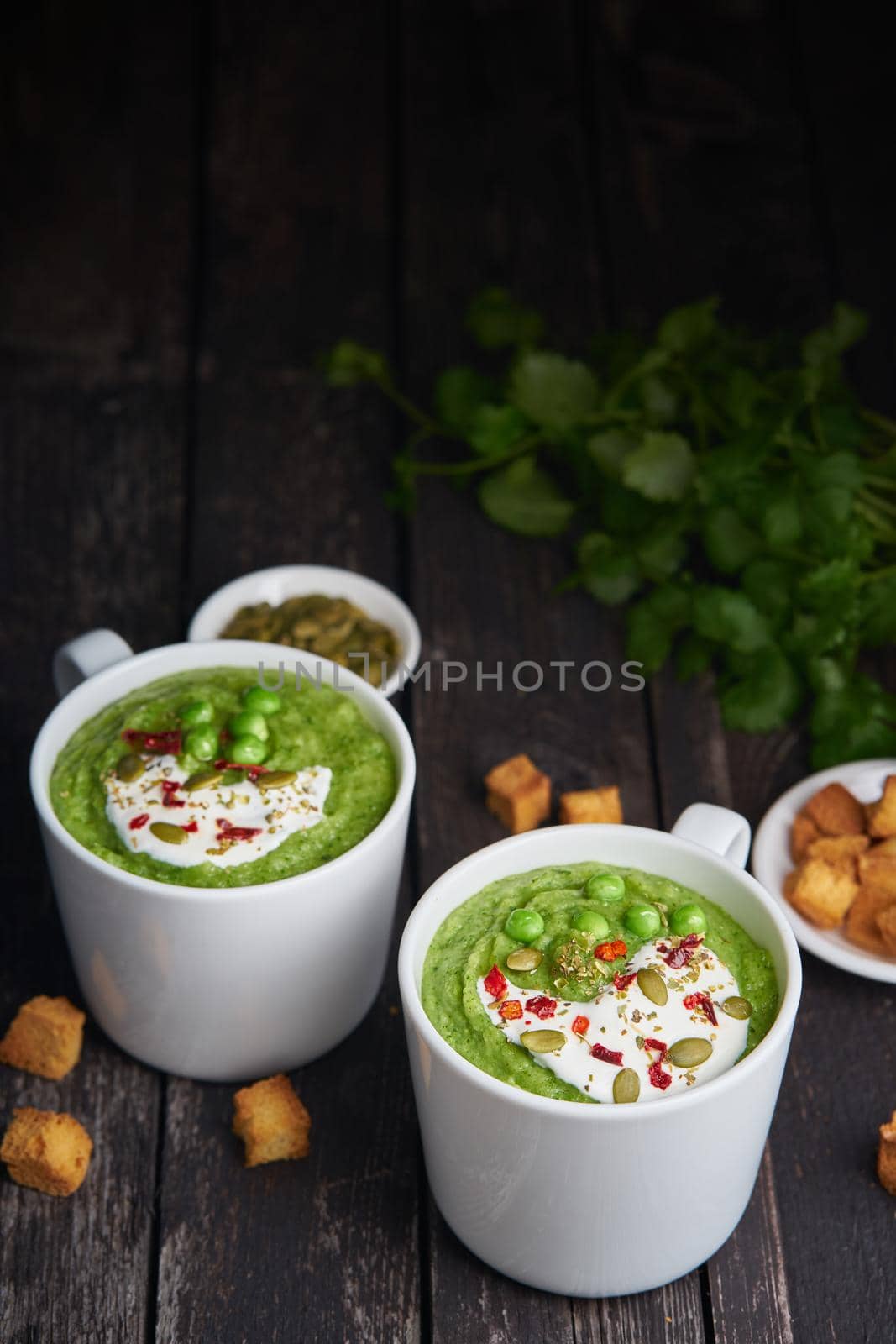 Broccoli cream soup on dark wooden background, vertical, copy space by NataBene