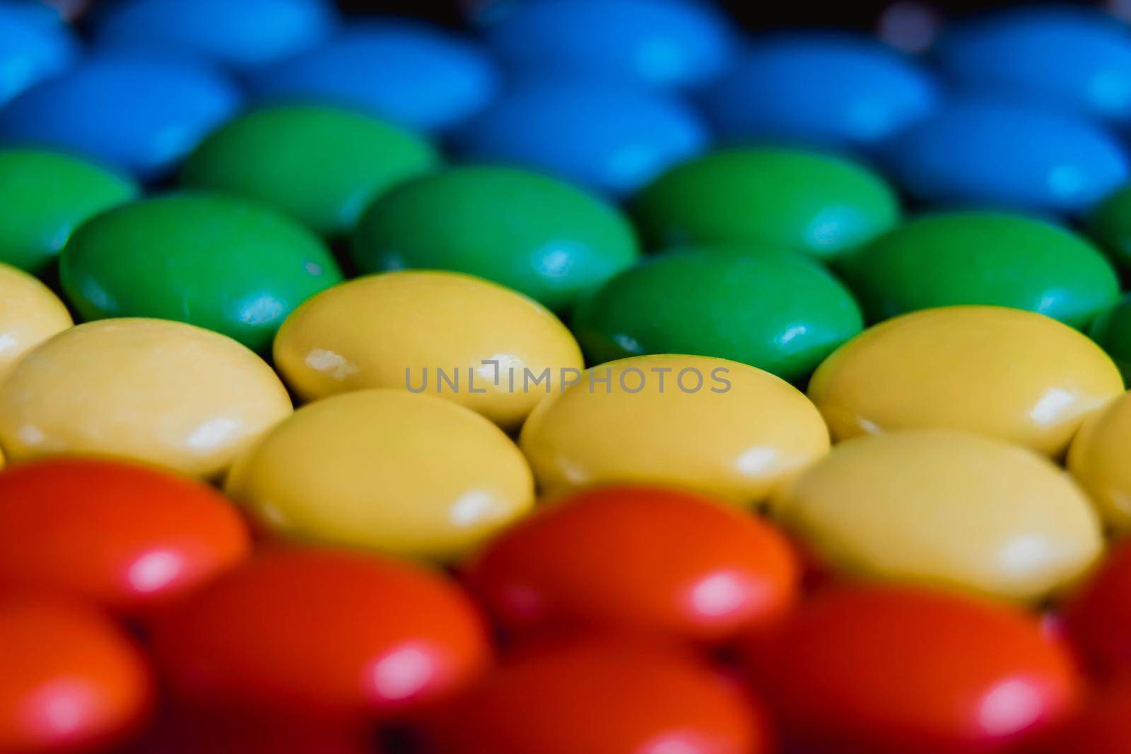 Rainbow of multicolored sweet candy dragees on isolated white background. Decorative Creative composition of round candy dragees in Rainbow colors. Concept Summer. Top view. Flat lay