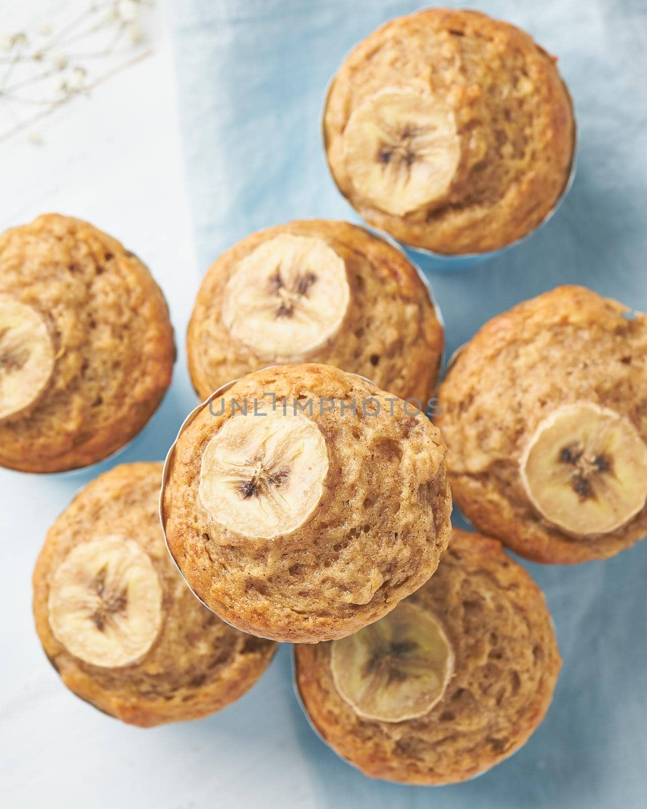 Banana muffin, top view, close up, vertical. Morning breakfast on blue napkin by NataBene