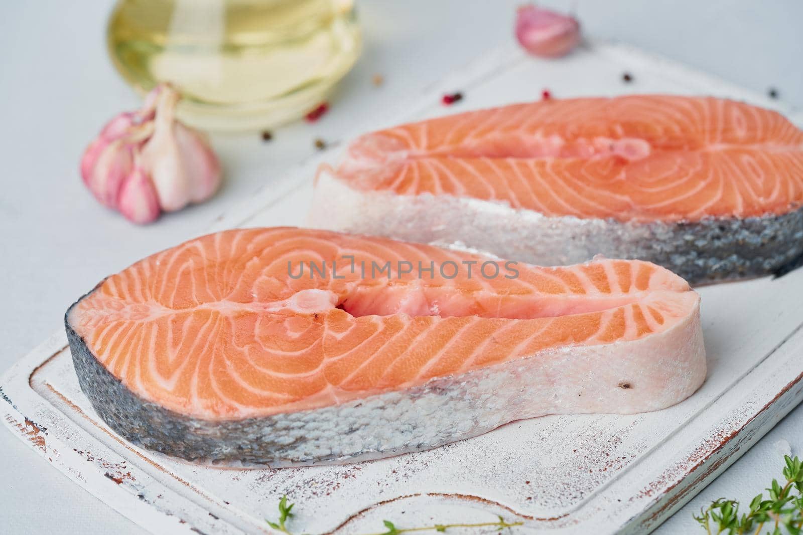 Two raw salmon steaks, fish fillet, large sliced portions on chopping board on table. Food background