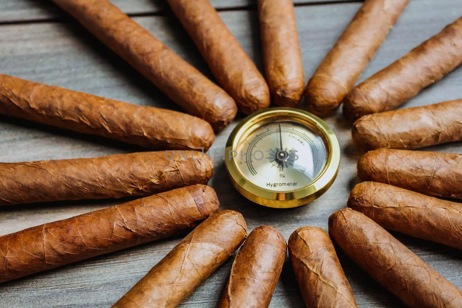 Cigars with humidor hygrometer on the wooden background